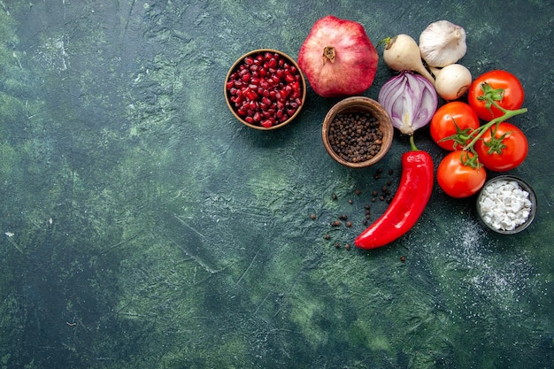 Top view fresh red tomatoes with garlic and seasonings on dark blue background pepper vegetable food salad