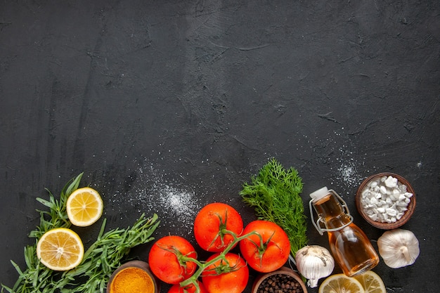 Top view fresh red tomatoes with lemon slices and garlic on dark table