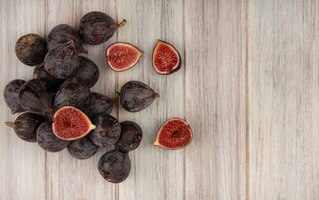 Top view of fresh ripe black mission figs isolated on a grey wooden wall with copy space