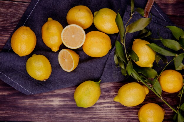 Top view of fresh ripe lemons on black fabric on rustic