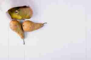 Free photo top view of fresh ripe pears in a sack on white wooden background with copy space