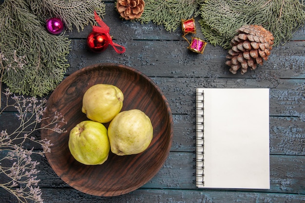 Top view fresh ripe quinces sour fruits inside plate on dark blue rustic desk fresh plant ripe tree fruit