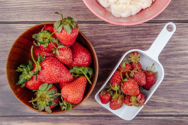 Top view of fresh ripe strawberries in a wood bowl on rustic