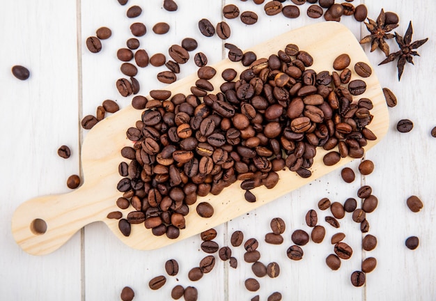 Top view of fresh roasted coffee beans isolated on a white wooden background