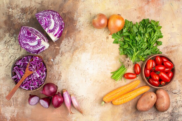 Вид сверху свежие ингредиенты салата, сделанные из пучка красной капусты, помидоров рома, петрушки, моркови, картофеля и лука на деревянном фоне с копией пространства