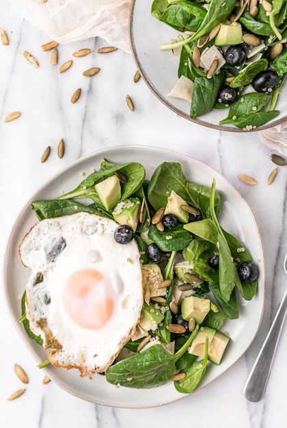 Top view of the fresh salad with a fried egg