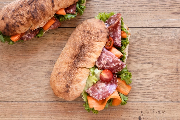 Top view fresh sandwiches assortment on wooden background