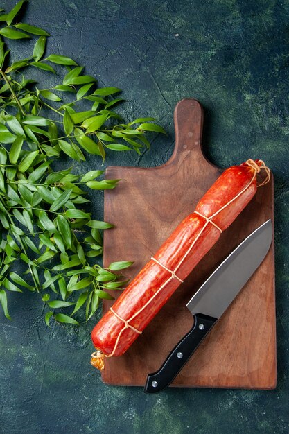 Top view fresh sausage with knife on dark-blue background bread bun meat burger animal meal sandwich food color