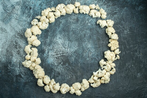 Top view fresh sliced cauliflower lined in circle on light-grey table