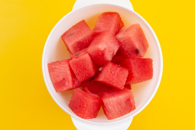 Free photo a top view fresh sliced watermelon inside white, plastic plate on yellow, fruit color summer