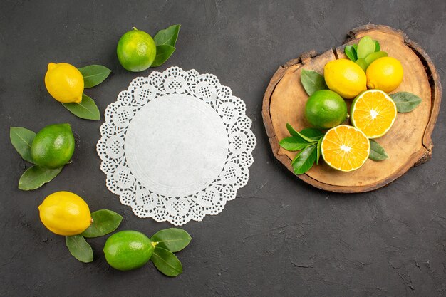 Top view fresh sour lemons on dark-grey floor fruit citrus lime