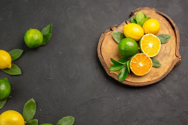 Top view fresh sour lemons on a dark-grey table fruit citrus lime