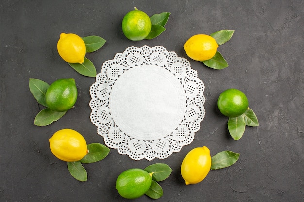 Top view fresh sour lemons on dark-grey table lime fruit citrus