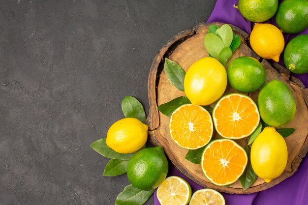 Top view fresh sour lemons on a dark table citrus lime fruit