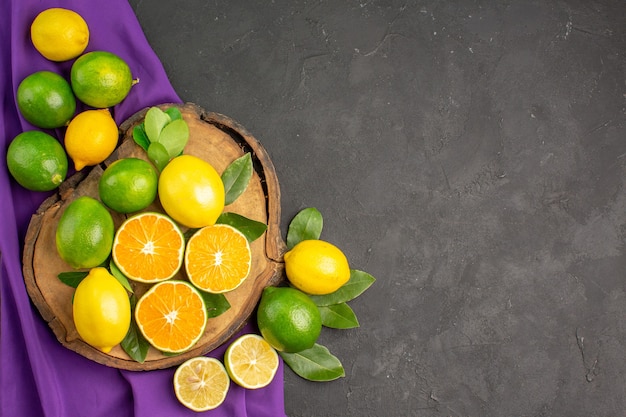 暗いテーブルの柑橘類のライムの果実の上面図新鮮なサワーレモン