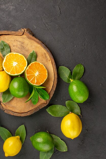 Top view fresh sour lemons on dark table fruits citrus lime