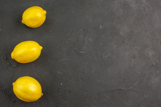 Free photo top view fresh sour lemons on dark table lime citrus yellow fruit