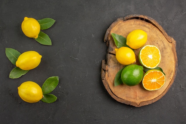 Top view fresh sour lemons on dark table lime citrus yellow fruit