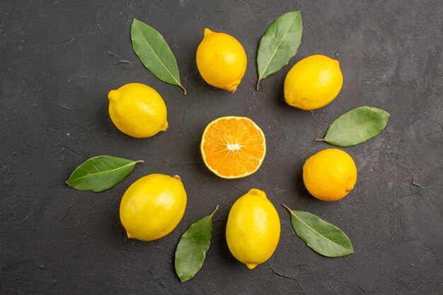 Top view fresh sour lemons lined on dark table citrus lime fruit yellow