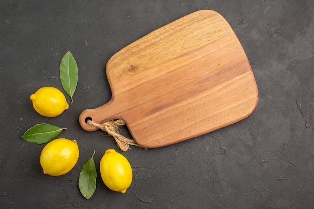 Foto gratuita vista dall'alto di limoni freschi e aspri rivestiti su tavola scura frutta giallo lime agrumi