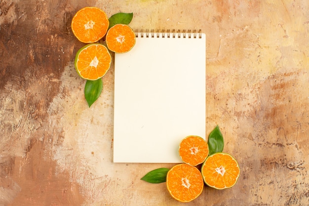 Free photo top view fresh sour tangerines with notepad