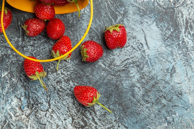 Top view fresh strawberries inside basket on dark-light table color berry fruit vitamine