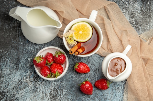 Free photo top view fresh strawberries with cup of tea on dark-light surface red fruits berry