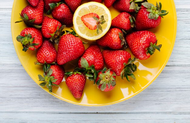 Top view fresh strawberry with slice of lemon on a plate