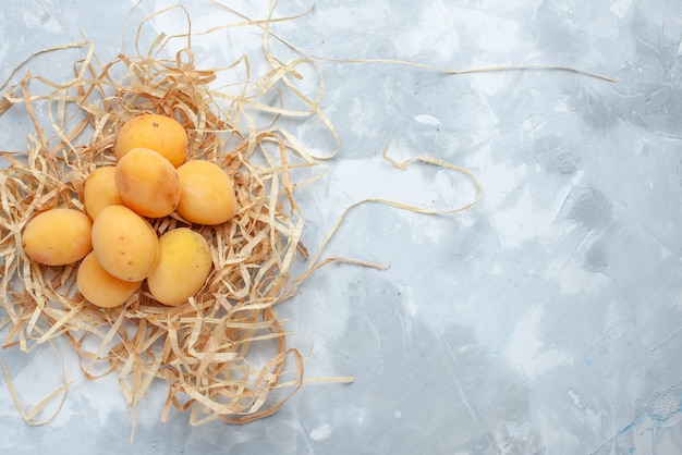 Foto gratuita vista dall'alto di frutta fresca di albicocche dolci su vitamina bianca a luce bianca, frutta cibo fresco