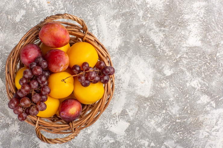 Free Photo top view fresh sweet apricots with plums and grapes inside basket on white desk