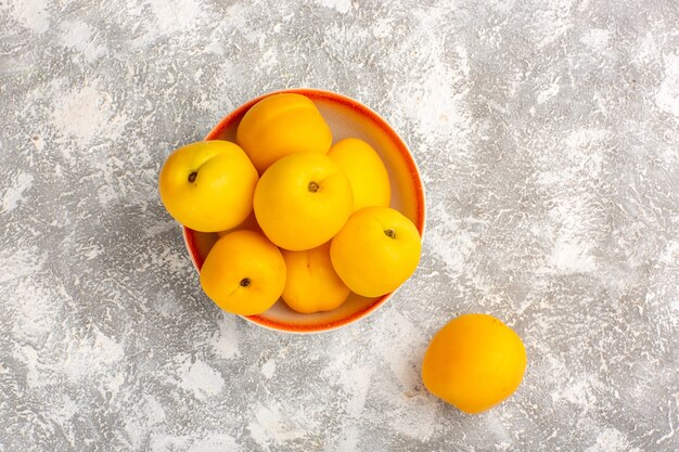 Top view fresh sweet apricots yellow fruits on white surface