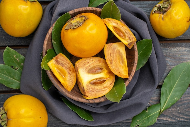 Бесплатное фото Вид сверху свежей сладкой хурмы на деревянном столе, спелых спелых фруктов