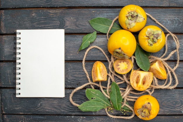 木製の素朴なテーブル、フルーツまろやかな上から見た新鮮な甘い柿