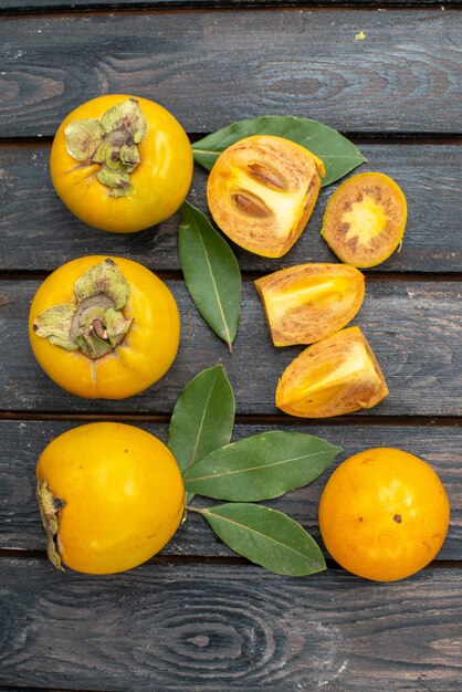 Top view fresh sweet persimmons on a wooden rustic table, fruit ripe mellow