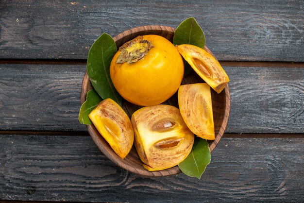 Top view fresh sweet persimmons on a wooden rustic table, mellow fruit health