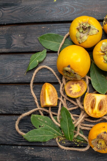 Top view fresh sweet persimmons on wooden rustic table, mellow fruit