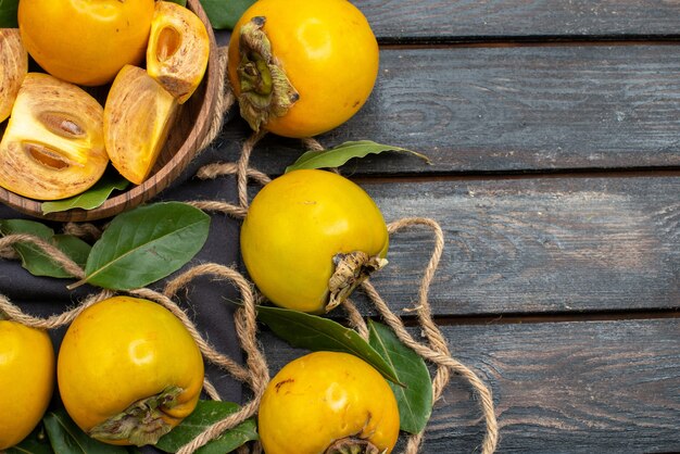 Top view fresh sweet persimmons on a wooden rustic table, ripe fruit