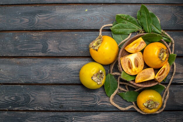 Top view fresh sweet persimmons on wooden rustic table, taste ripe fruit