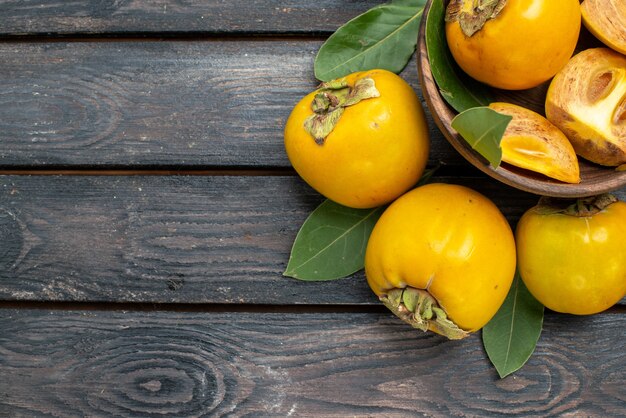 Top view fresh sweet persimmons on wooden table, fruit mellow ripe