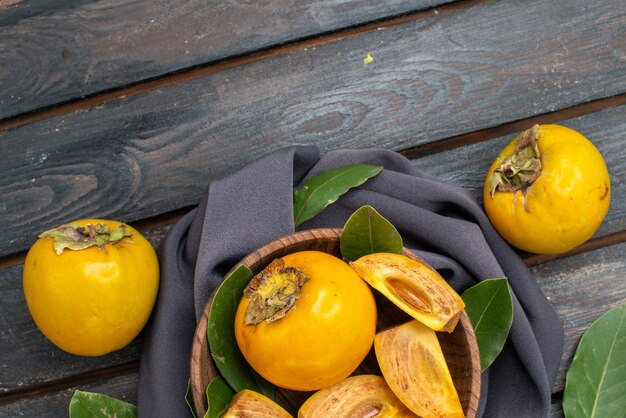 Top view fresh sweet persimmons on a wooden table, fruit ripe mellow