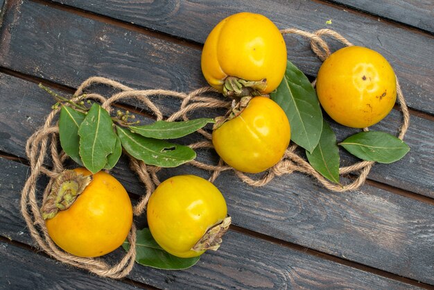 Top view fresh sweet persimmons on a wooden table, ripe fruit taste