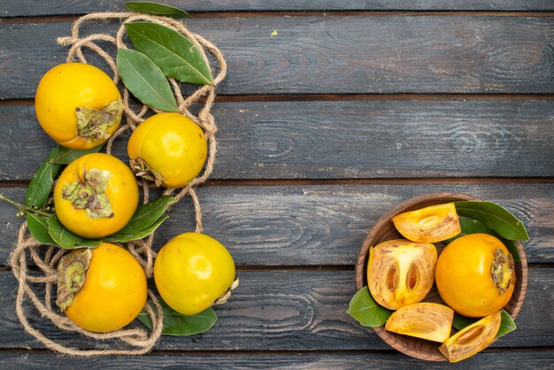 Top view fresh sweet persimmons on wooden table, ripe fruits taste