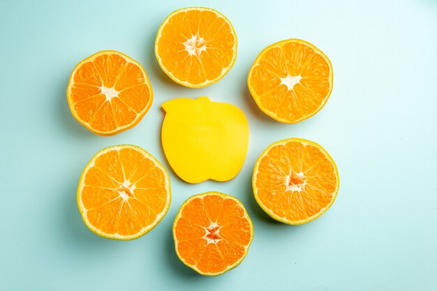 Top view fresh tangerine slices with sticker on the light-blue background