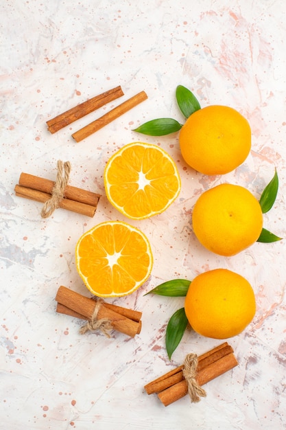 Free photo top view fresh tangerines cinnamon sticks on bright surface