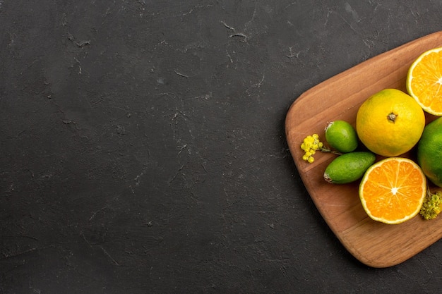 Top view of fresh tangerines with feijoa on black