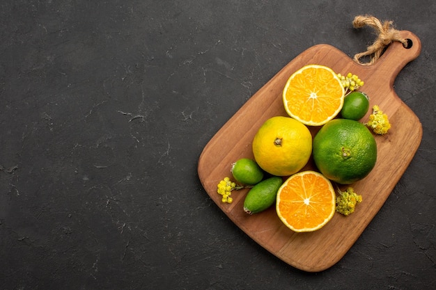 Foto gratuita vista dall'alto di mandarini freschi con feijoa su nero