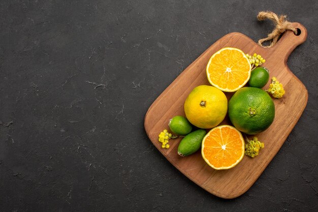 Top view of fresh tangerines with feijoa on black