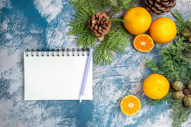 Top view fresh tangerines with green branches on a light-blue background