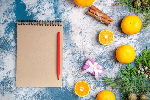 Free photo top view fresh tangerines with notepad on light-blue background