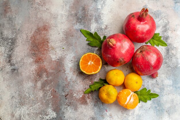 Top view fresh tangerines with pomegranates on light background